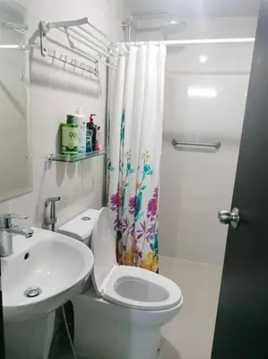 a bathroom with a toilet and a sink and a shower curtain at Cubao Manhattanheights U31N TB, Studio Unit in Manila