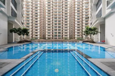 a large swimming pool in front of a large building at StayHere The Florence Luxe 1BR Near Venice Mall in Manila