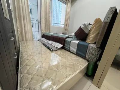 a bed sitting in a room with a window at Jazz Residences Makati in Manila