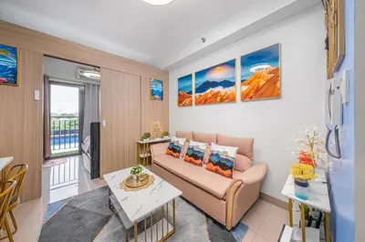a living room with a couch and a table at 2 Side-by-Side P00L Front Condos, 6 Beds, 2 CR, 2 Kitchen at MOA in Manila