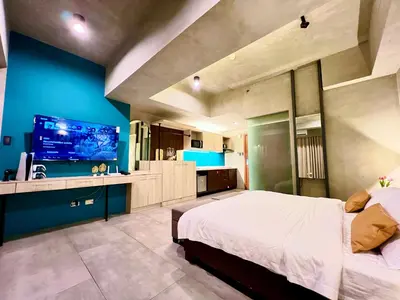 a bedroom with a large bed and a blue wall at Cozy Spacious Hotel Type Condo with PS5 Smart TV and WiFi in Manila