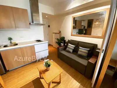 a living room with a couch and a kitchen at Azure Urban Resort Staycation by LV in Manila