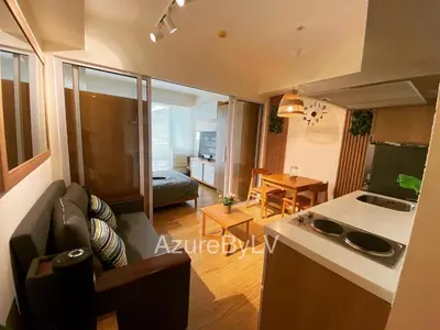 a living room with a couch and a kitchen at Azure Urban Resort Staycation by LV in Manila
