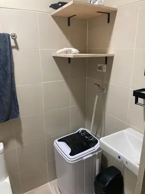 a small bathroom with a trash can and a sink at Penthouse studio at Fame Residence 41st Floor, ShangriLa-Megamall in Manila
