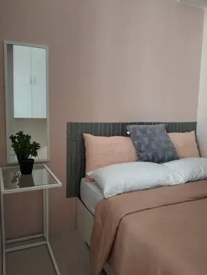 a bedroom with a bed with a mirror and a table at Cozy 2BR corner unit in a prime location, your perfect city home in Manila