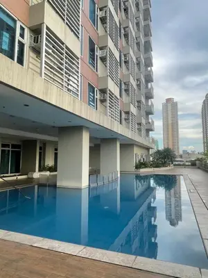 a swimming pool in front of a building at 1 Bedroom Condo near US Embassy and St Lukes Medical Clinic in Manila