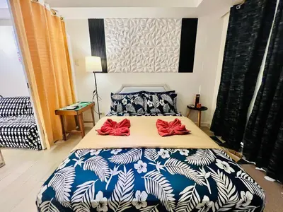 a bedroom with a bed with two red bows on it at Scr AzureINetflixIBalconyIGames in Manila