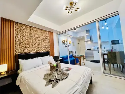 a bedroom with a bed and a dining room at Scr GlamourINetFlixIBalconyICozy in Manila