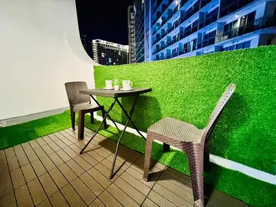 a small table and chairs on a green wall at Scr GlamourINetFlixIBalconyICozy in Manila