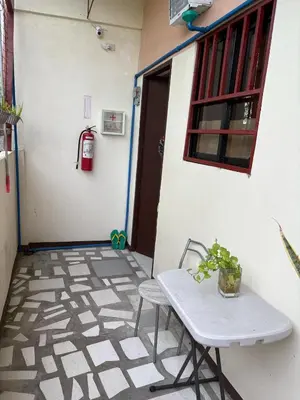 a white table and chair in front of a building at AIRPORT VILLAMOR TRANSIENT ROOMS in Manila