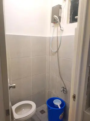 a small bathroom with a toilet and a shower at AIRPORT VILLAMOR TRANSIENT ROOMS in Manila
