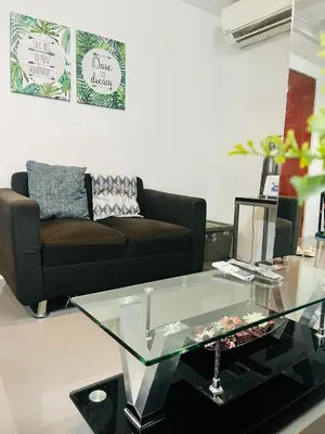 a living room with a couch and a glass coffee table at ADB Tower 1 bedroom with fast wifi and Netflix at Ortigas across Robinson's Galleria in Manila