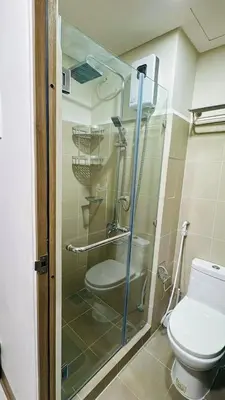 a glass shower in a bathroom with a toilet at Coast Residences - 2 Bedroom with Balcony facing Mall of Asia, Manila Bay & Pool View in Manila