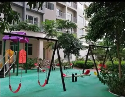 a playground in front of a building with swings at Chic 2BR Condo Unit at South Residences in Manila