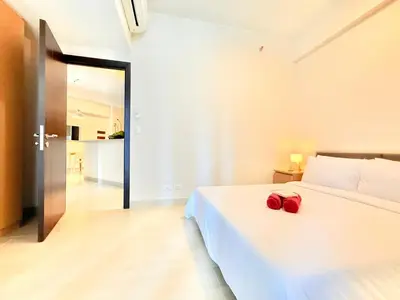 a bedroom with a white bed with a red bag on it at Uptown Parksuites BGC in Manila