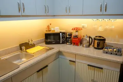 a kitchen counter with a sink and a microwave at Alea Residences in Manila