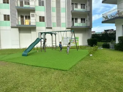 two children playing on a playground in a yard at Field Residence SMDC 1BR w/ Netflix in Manila