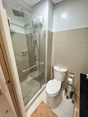 a bathroom with a toilet and a glass shower at M&M Condostay at Shore 2 Residences Tower 2 Pasay City in Manila