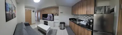 a kitchen with a stainless steel refrigerator and wooden cabinets at A&R Condo by the Bay in Manila