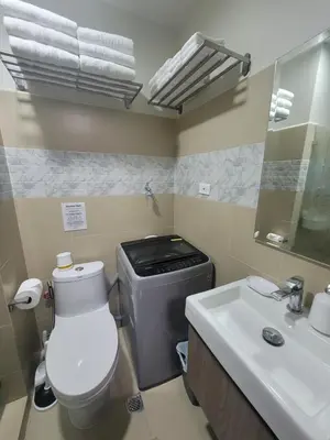 a bathroom with a toilet and a sink at A&R Condo by the Bay in Manila