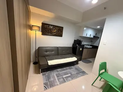 a small living room with a couch and a kitchen at Elresa Elegant at Field Residences Condominium Hotel in Manila