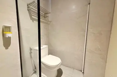 a bathroom with a toilet and a shower at Aurora Suites Pasay near Airport in Manila