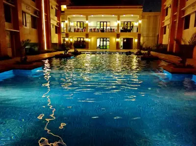 a large swimming pool in a building at night at Rafaella Sunset - Deluxe Room in Manila