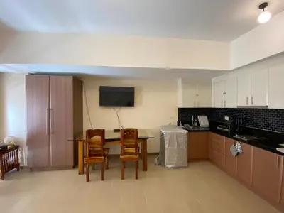 a kitchen with a table and chairs and a kitchen with a counter at Spacious condo in Venice Luxury Residences in Manila