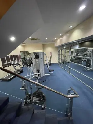a gym with several treadmills and machines at Pearl Of The Orient Tower, in front of US Embassy in Manila