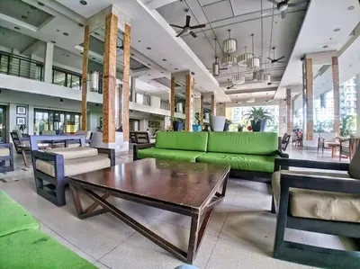 a living room with a green couch and a table at Modern Condo Apt in Flair Tower South, Mandaluyong in Manila