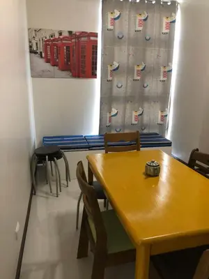 a room with a table and chairs and red phone booths at 101 Newport Boulevard-Favila Condotel Unit near Airport in Manila