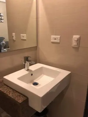 a white sink in a bathroom with a mirror at 101 Newport Boulevard-Favila Condotel Unit near Airport in Manila
