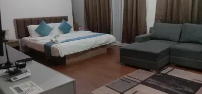 a bedroom with a bed and a couch and a chair at accommodation service in Manila