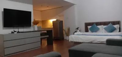 a bedroom with a tv and a bed with a couch at accommodation service in Manila