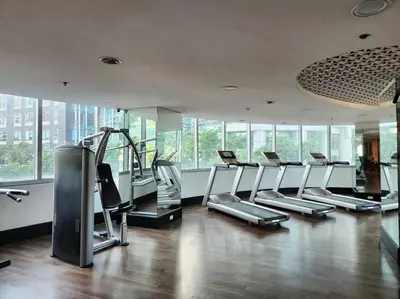 a gym with a bunch of cardio equipment in a room at BGC Fresh & Cozy Studio near Burgos Circle with Fast Internet Connection in Manila