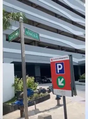 a parking sign in front of a building with a parking meter at Coast Residence 4026 PENTHOUSE 1 Bedroom Condo with Wifi & Netflix in Manila