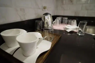a black counter with cups and glasses on it at Luxe in Venice in Manila