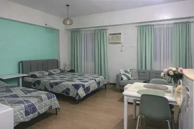 a hotel room with two beds and a living room at J & F Homestay - Cavite, Philippines in Trece Martires