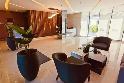 a lobby with a potted plant and a table and chairs at Condominium at Spring Residences near Airport in Manila