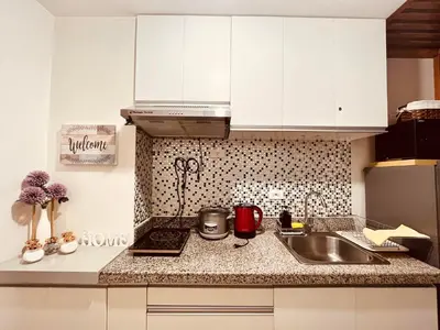 a kitchen with white cabinets and a sink at Condominium at Spring Residences near Airport in Manila