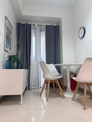 a living room with a table and two white chairs at Hygge Suite @ Moa complex near Naia, Ccp , Dfa in Manila