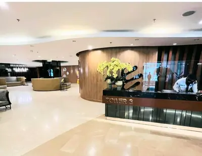 a lobby of a hotel with a reception desk and flowers at Shore 2 Condo unit near MOA in Manila