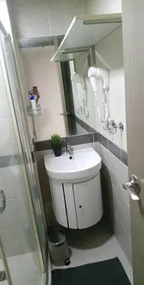 a bathroom with a white sink and a shower at Larue cozy room in Solemare Parksuites Paranaque in Manila