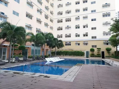 a swimming pool in front of a building at Serenity Suites: Your tranquil gateway! in Biñan