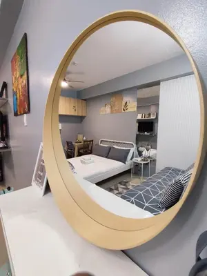 a large circular mirror in a living room with a bed at Homestay Manila Mall of Asia Shore Residences at TresMarias' in Manila