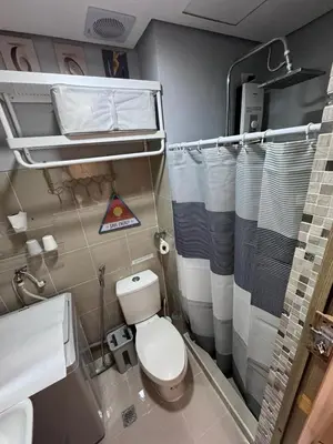 a bathroom with a toilet and a sink and a mirror at Homestay Manila Mall of Asia Shore Residences at TresMarias' in Manila