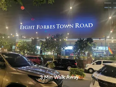 a parking lot with cars parked in front of a car dealership at Caleze Properties AVANT at the Fort BGC Studio in Manila