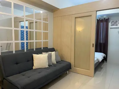 a living room with a couch and a bedroom at Jazz Residences Makati City by darpm in Manila