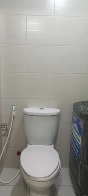 a bathroom with a white toilet and a trash can at Jazz Residences Makati City by darpm in Manila