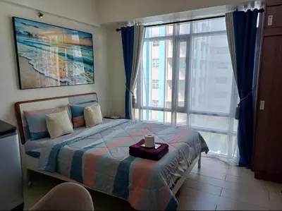 a bedroom with a bed with a candle on it at Pasay Staycation with Parking Space in 150 Newport Boulevard near Resort World & NAIA T3 in Manila